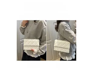 Detail view of white geometric quilted bag showing crossbody and shoulder style functions