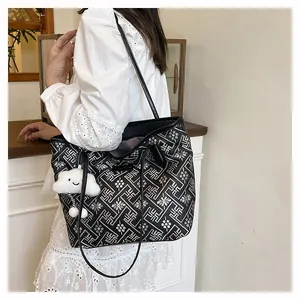 Close-up of modern tote bag with traditional pattern and white plush cloud charm