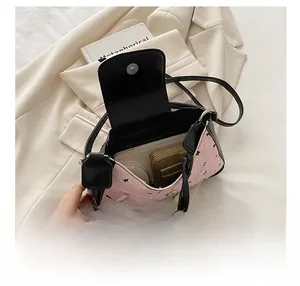 Detail shot of the pink bow shoulder bag interior showing capacity for phone and wallet