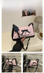 Detail of pink bow shoulder bag with pleated texture and silver heart pendant charm