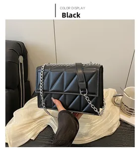 Macro detail of black quilted crossbody bag with triangular geometric embossed pattern