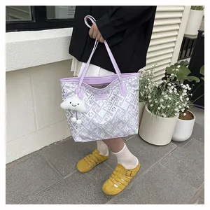 Detail of purple geometric brocade tote bag with a white cloud charm in outdoor setting
