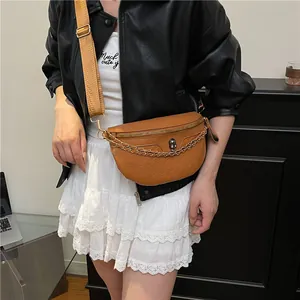 Brown leather crossbody chest bag with skull relief and metal chain on model