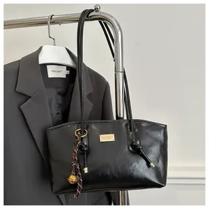 Classic black glossy leather tote bag with gold nameplate and striped bell charm