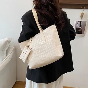 Beige tote bag with houndstooth texture and small pouch in a stylish lifestyle scene