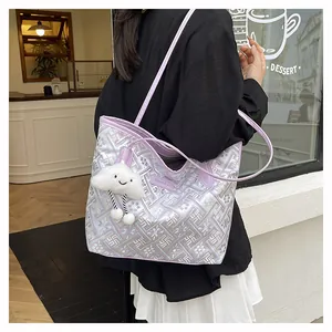 Detail view of purple geometric pattern tote bag with a white fluffy cloud pendant charm