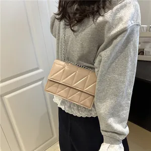 Beige quilted crossbody bag with silver chain strap and geometric stitching pattern