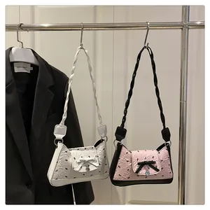 Close-up of pleated texture on bow shoulder bags with woven straps and heart charms