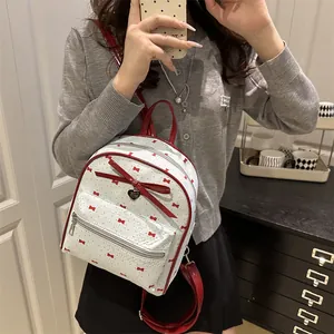 White mini backpack with red bow print and large lacquer bow detail for daily use