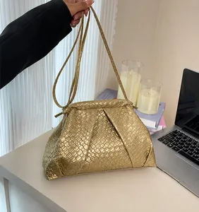 Detail of gold woven cloud bag showing metallic texture and braided chain strap