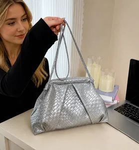 Detailed view of silver woven cloud bag with leather texture and matching shoulder strap