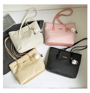 Top view of tote bags in four colors with plush monster charms and metal logo plates