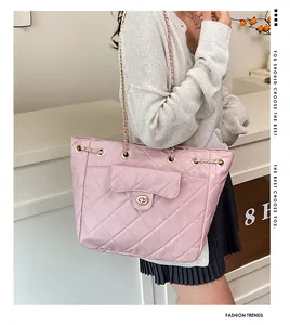 Detail of pink quilted tote bag with golden metal chain strap and twist lock closure