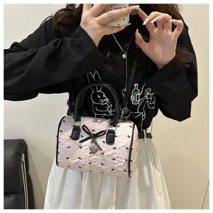 Pink balletcore cylinder bag featuring pleated texture and black bow charm detailing
