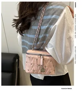 Borsa rosa trapuntata con tracolla a catena e ciondolo a rosa indossata dal modello