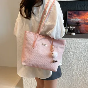 Pink textured tote bag for women with plush charm and metal plaque on shoulder strap