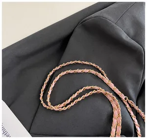 Detail showing the light pink leather and gold metal chain shoulder strap design