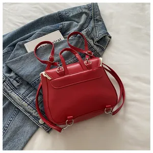 Detail of red small backpack featuring elegant white lace edges and smooth PU leather texture
