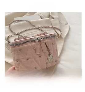 Dettaglio della borsa rosa trapuntata con borchie argento e ciondolo a rosa in metallo