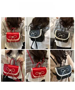 Detail view of mini bow backpack with lace trim in red and black colors for women