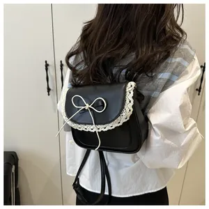 Detailed back view of a black leather mini backpack with lace trim and bow knot detail