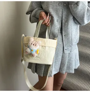 Detail der Canvas-Beuteltasche mit PAR TOP-Stickerei und rosa Plüsch-Hasenanhänger