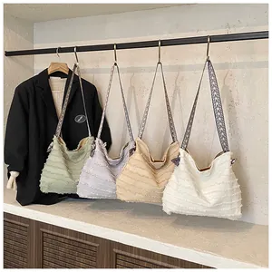 Detail of four colorful straw tote bags with fringe texture and ethnic pattern straps