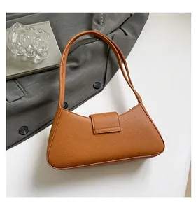 Gros plan d'un sac baguette en cuir marron texturé avec boucle et bandoulière chic