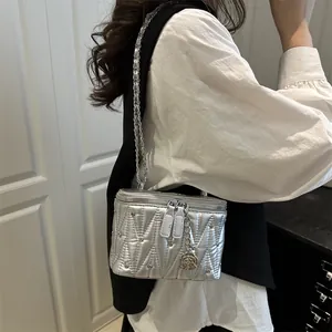 Piccola borsa trapuntata argento con tracolla a catena e ciondolo a rosa vista su modella