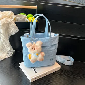 Hellblaue Eimertasche aus Nylon mit Teddybär-Anhänger und verstellbarem Schultergurt