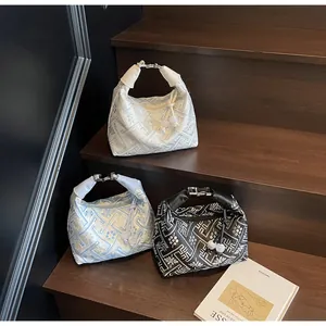 Detailed macro of three jacquard dumpling bags with floral patterns and silver clasps