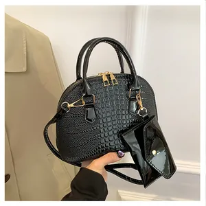 Detailed macro view of black crocodile pattern shell bag with golden hardware