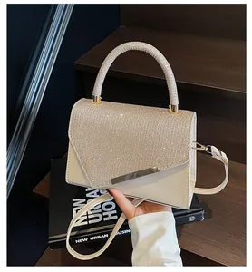 Détail d'un mini sac en cuir crème avec rabat en strass étincelants et anse ronde
