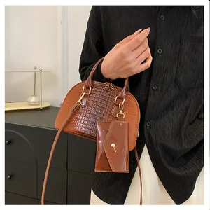 Detailed view of a brown crocodile pattern shell bag with a matching coin purse