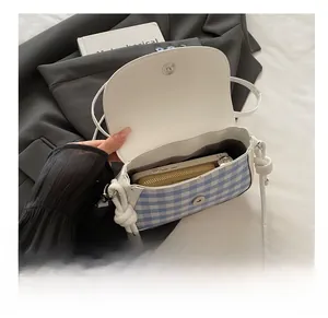 Internal storage detail showing capacity for a long wallet and phone in the plaid saddle bag