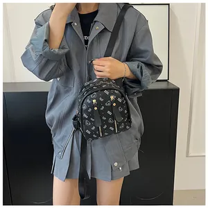 Détail du sac à dos noir avec imprimé ours blanc et poches zippées verticales
