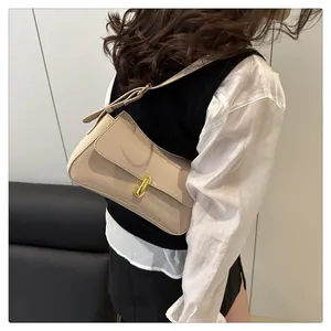 Detail of cream underarm bag with glossy finish and gold twist lock on a model