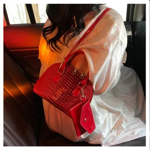 Detail of red crocodile pattern shell bag with mini coin purse in a car interior