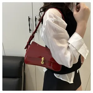 Close-up of vintage dark red patent leather bag with elegant gold metallic lock