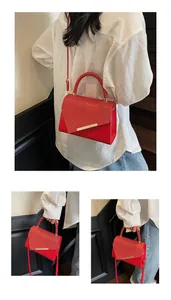 Détail du sac à main rouge pailleté avec texture cuir et boucle en métal doré