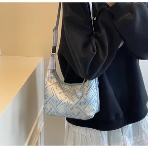 Detailed close-up of blue floral embroidery on fabric hobo shoulder bag for women