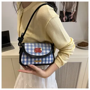 Blue and white checkered mini bag with red apple embroidery shown on a model