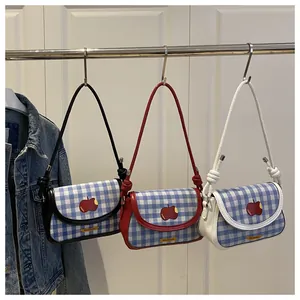 Detail showing checkered crossbody bags with apple embroidery and stylish knot shoulder straps