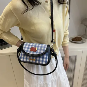 Blue plaid saddle crossbody bag with red apple embroidery and adjustable black strap