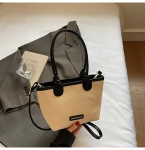 Detail der gewebten Strohtasche mit schwarzem Lederbesatz und Kontrastnähten für Damen