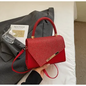 Détail du sac rouge avec rabat scintillant à paillettes et élégante garniture dorée