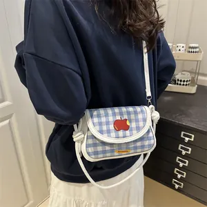 Plaid mini crossbody saddle bag with red apple embroidery and white shoulder strap