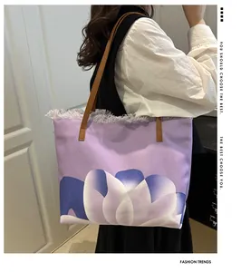 Detalle del bolso tote de lona morada con estampado de loto y borde desflecado