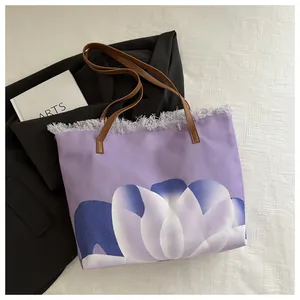 Detalle de bolso tote de lona púrpura con estampado de tulipanes y flecos grises