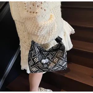 Detail of white embroidery and frosted bead zipper pull on the black crescent hobo bag